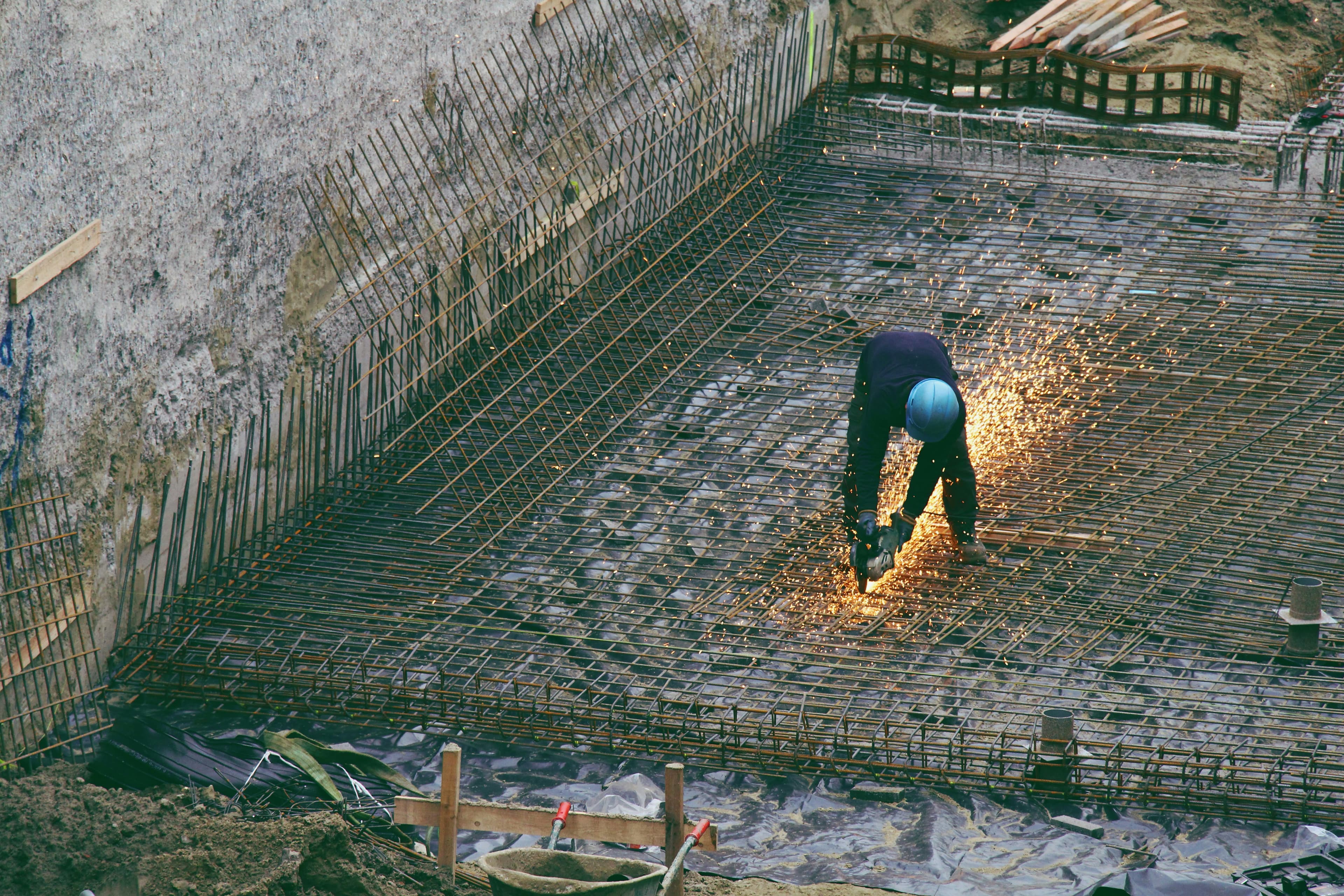 Worker welding reinforcement steel bars with sparks flying
